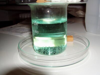 The solution colored by the dissolved copper